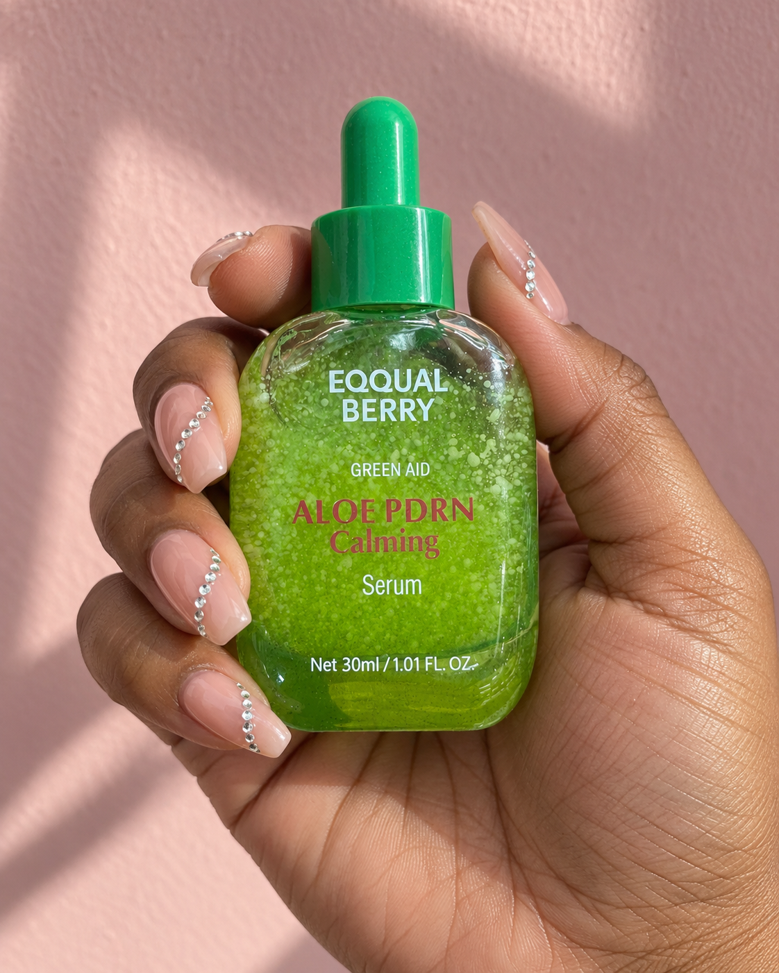 EQQUALBERRY – Green Aid Aloe PDRN Calming Serum 30 ml — présentation du produit tenu en main sur fond rose, visuel illustratif